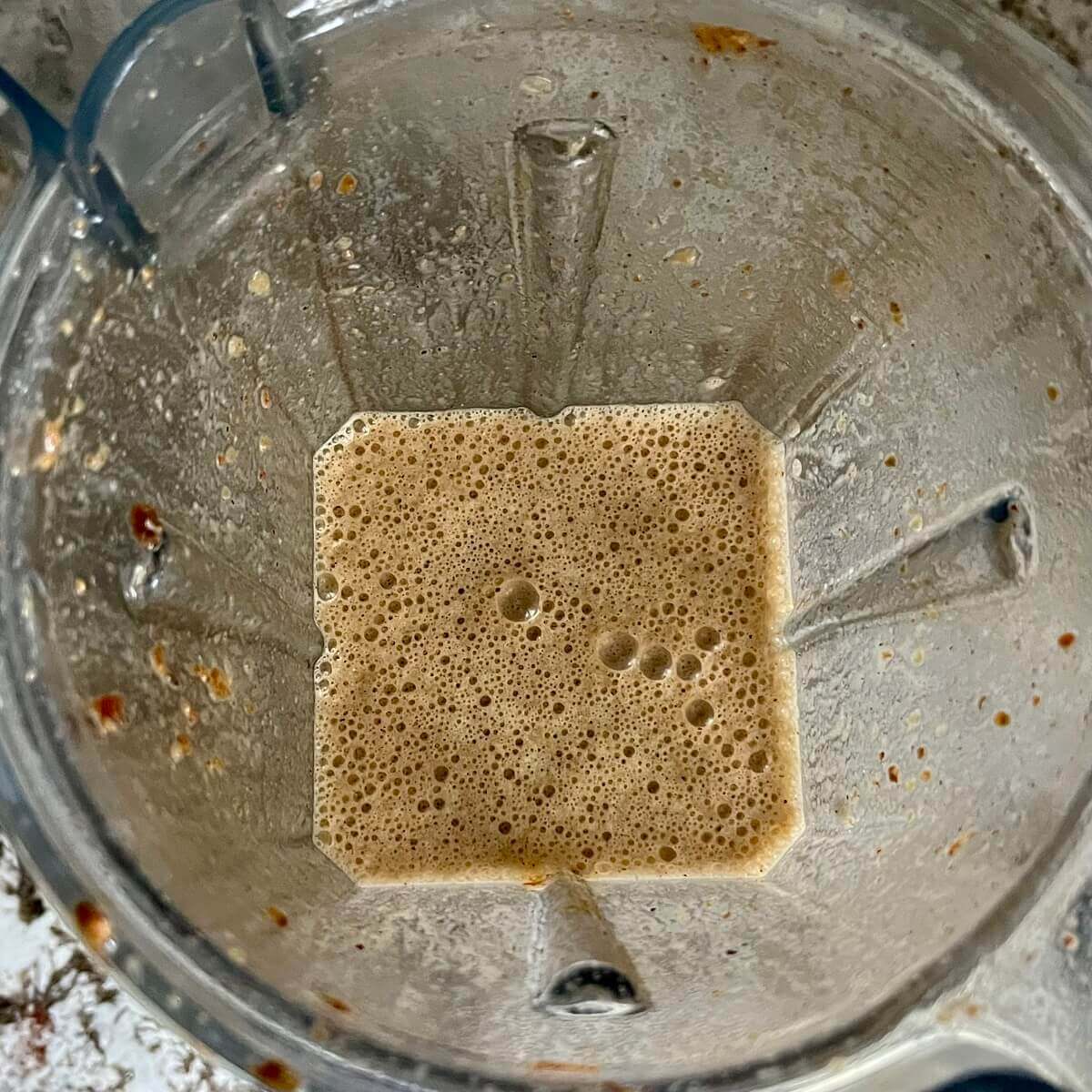 A blended light brown smoothie in a blender.