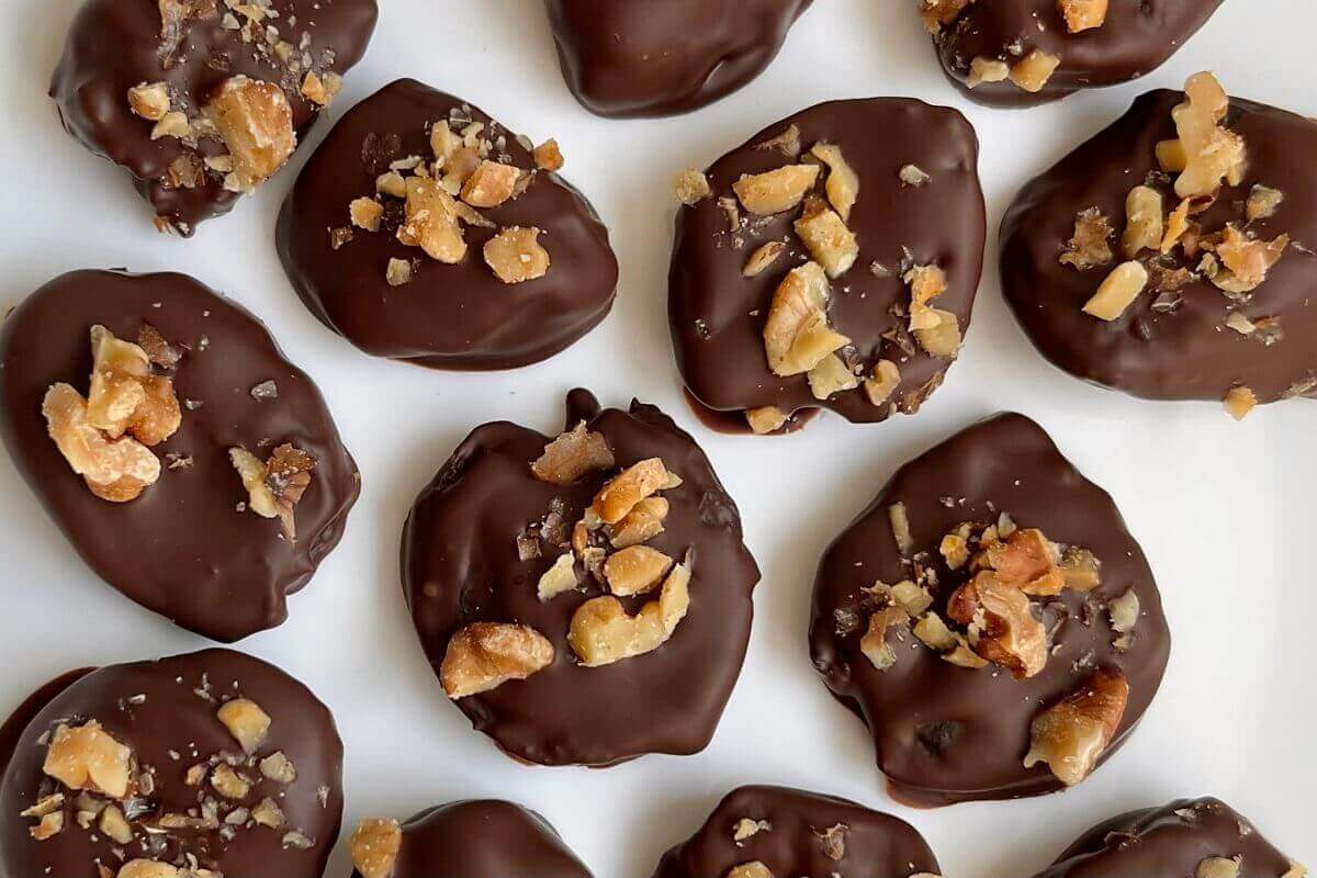 Prune chocolate treats on a white plate.