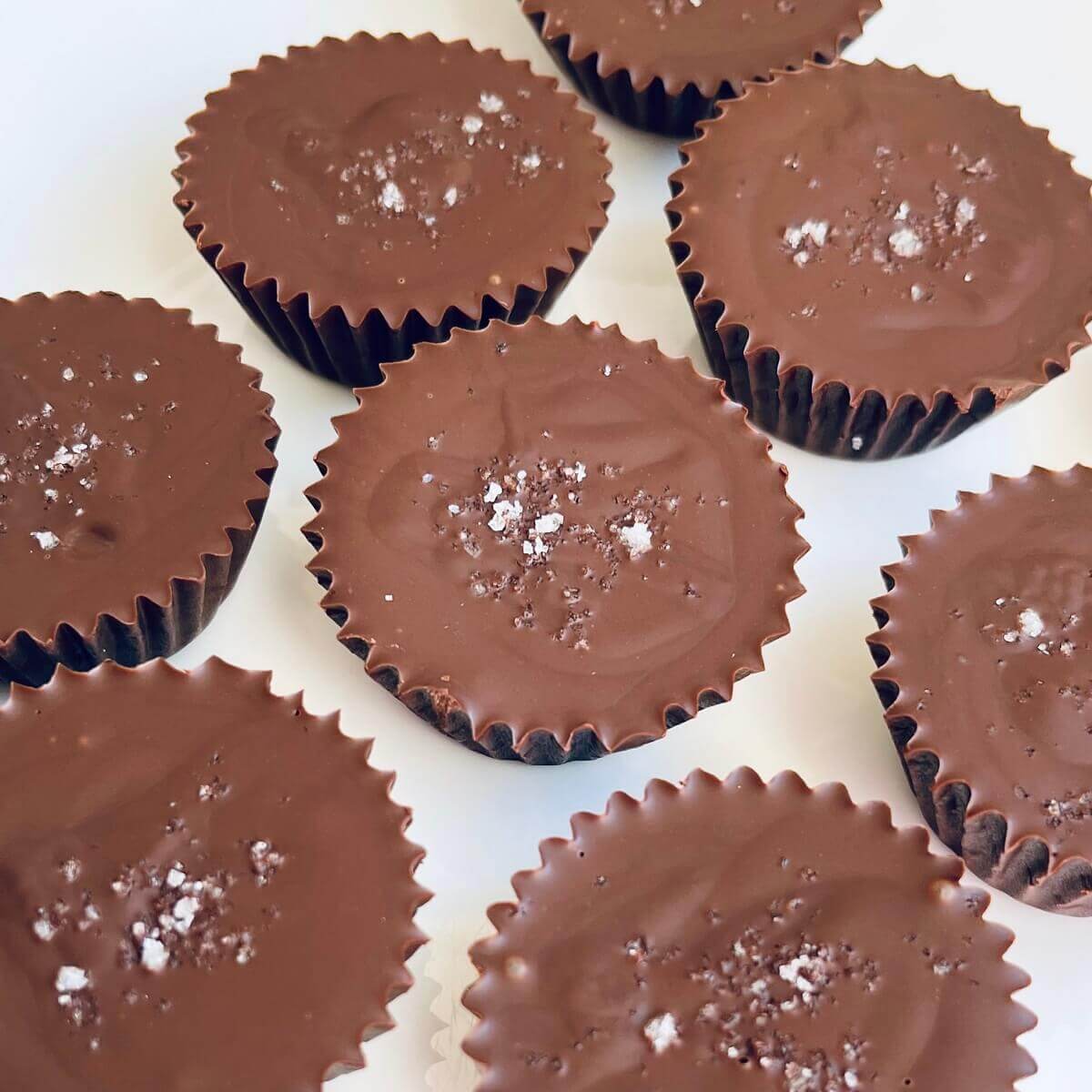 Sunflower seed butter cups sprinkled with sea salt on a white plate.