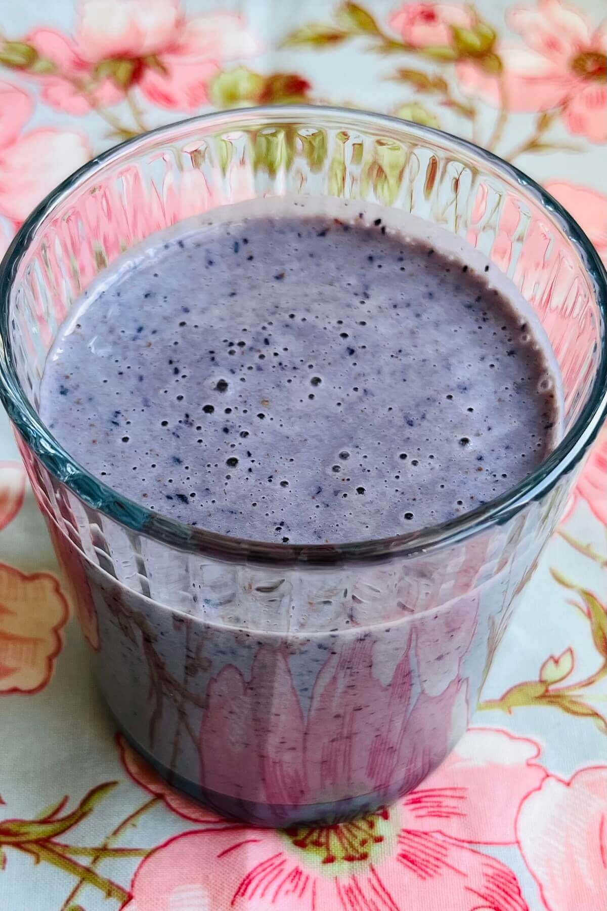 A smoothie made with blueberries and almond butter in a glass.