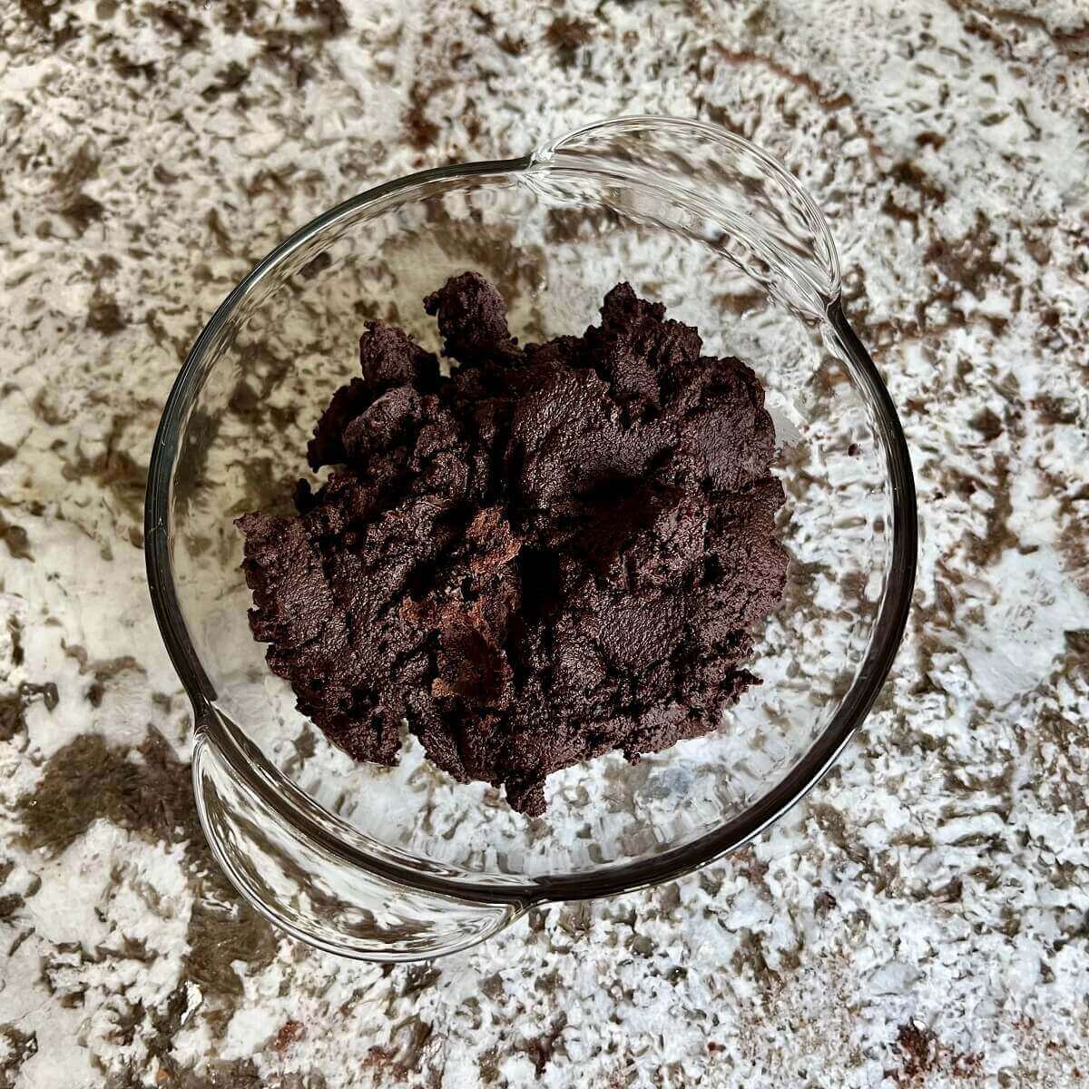 A mixture of avocado and chocolate in a glass bowl.