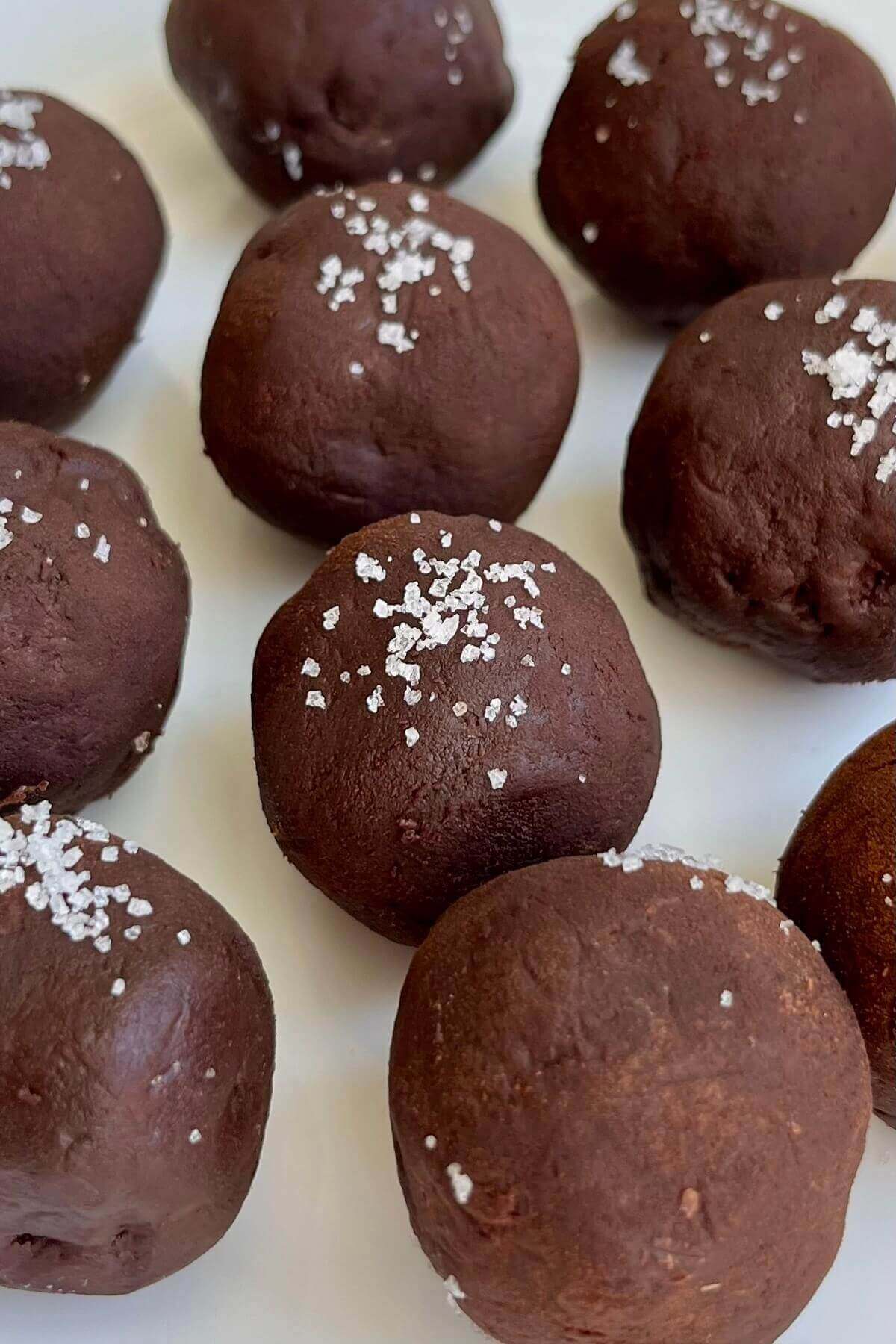Avocado truffles on a white plate.