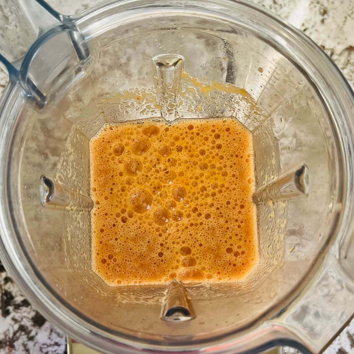 Am orange colored smoothie blended in a blender.