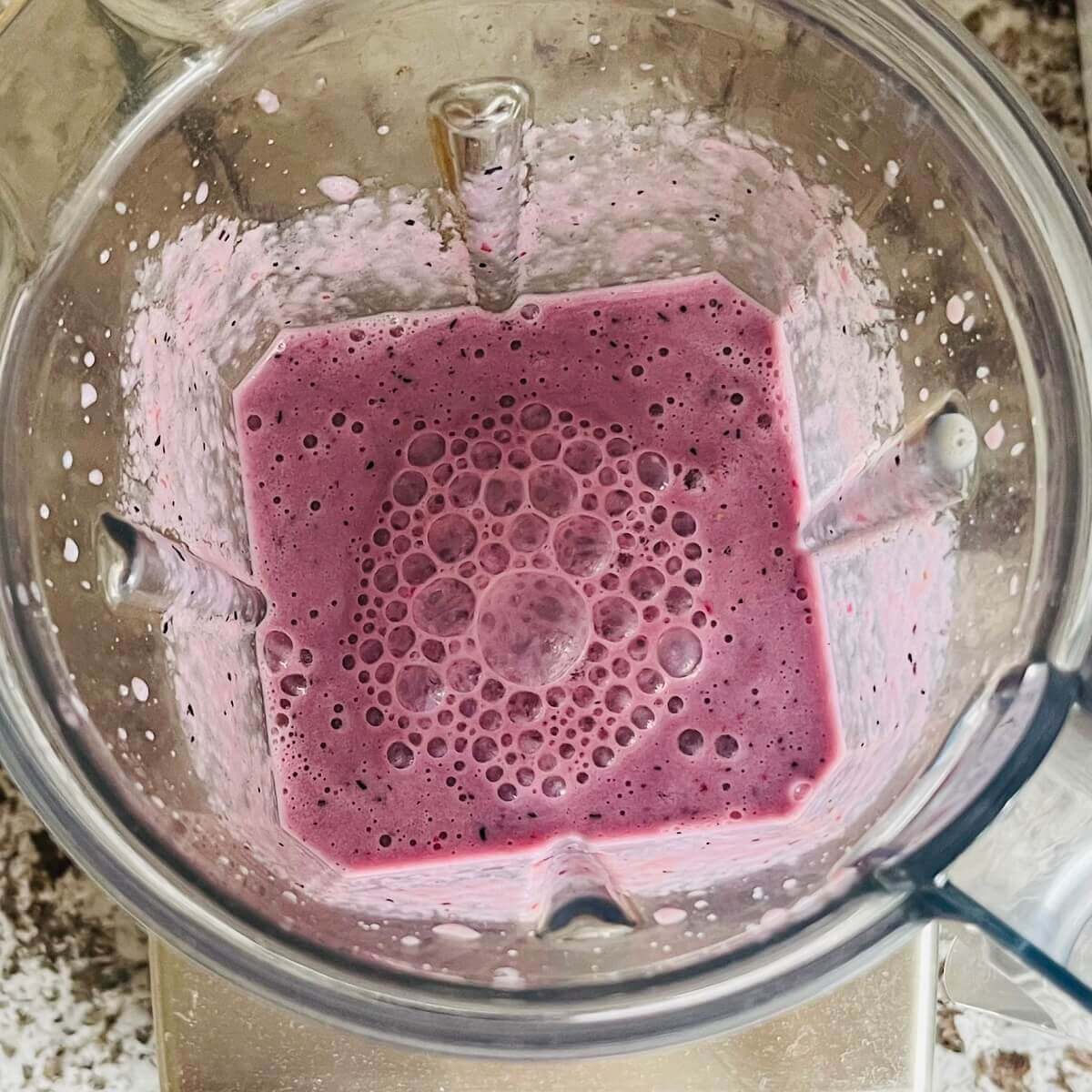 A blended fruit smoothie in a blender.