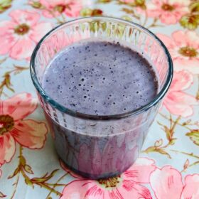 A blueberry almond butter smoothie in a glass.