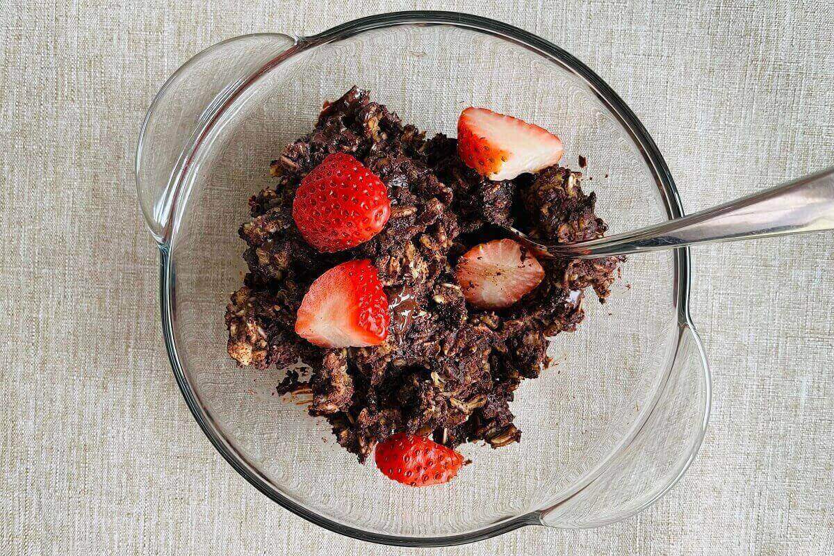 Brownie baked oatmeal in a glass bowl with a spoon.