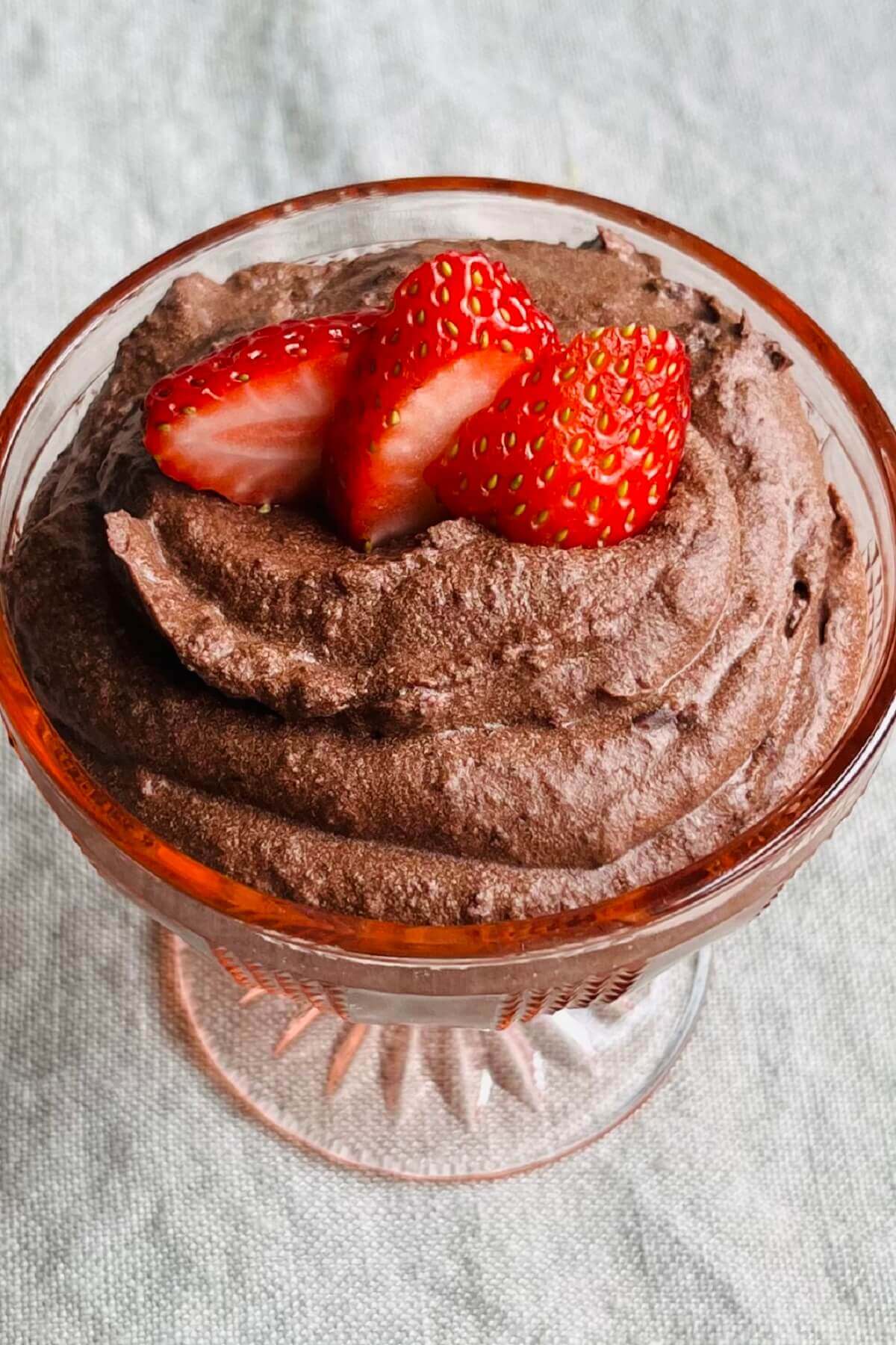 Chocolate black bean mousse garnished with strawberry slices in a glass dish.