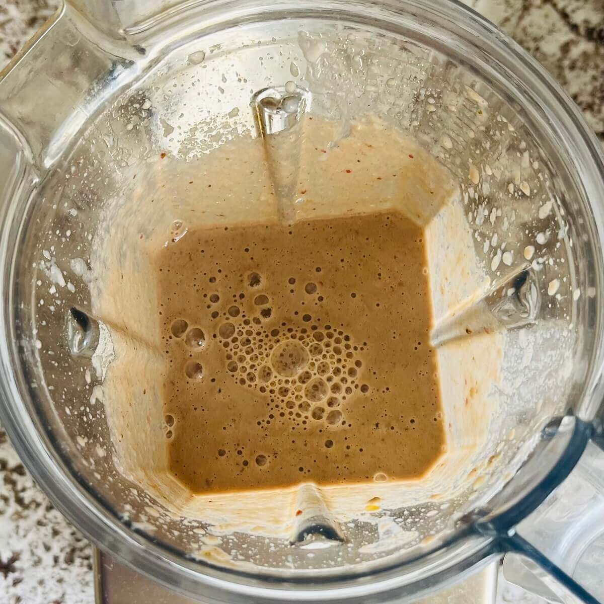 A creamy apple smoothie in a blender.