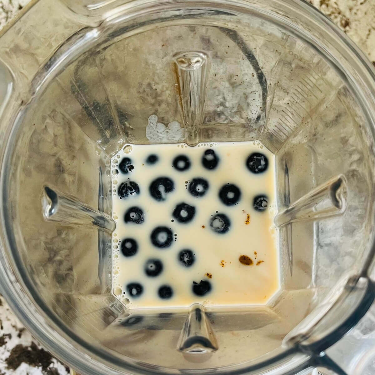 Blueberries, almond butter, and other ingredients in a blender.