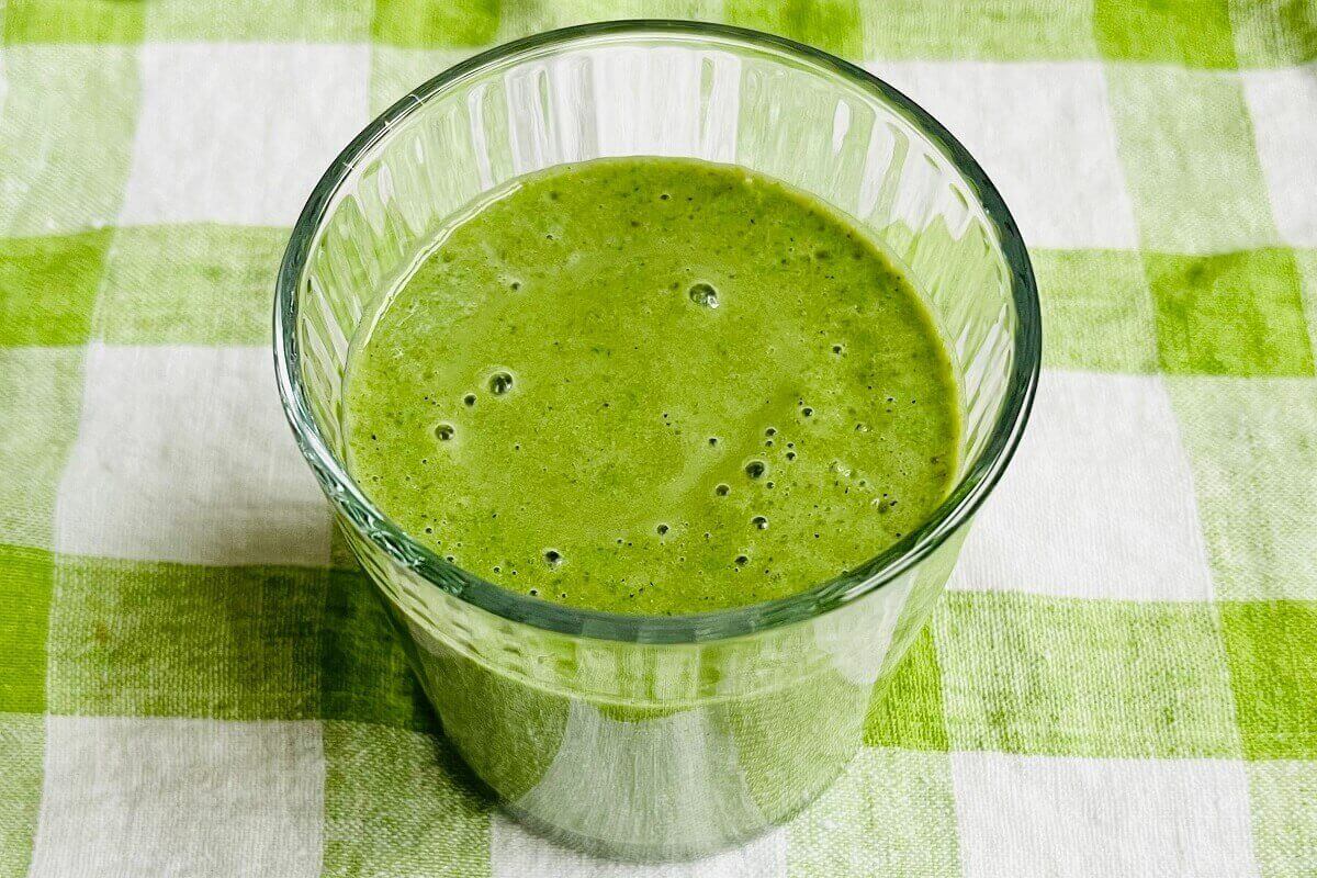 A kale and banana smoothie in a glass.
