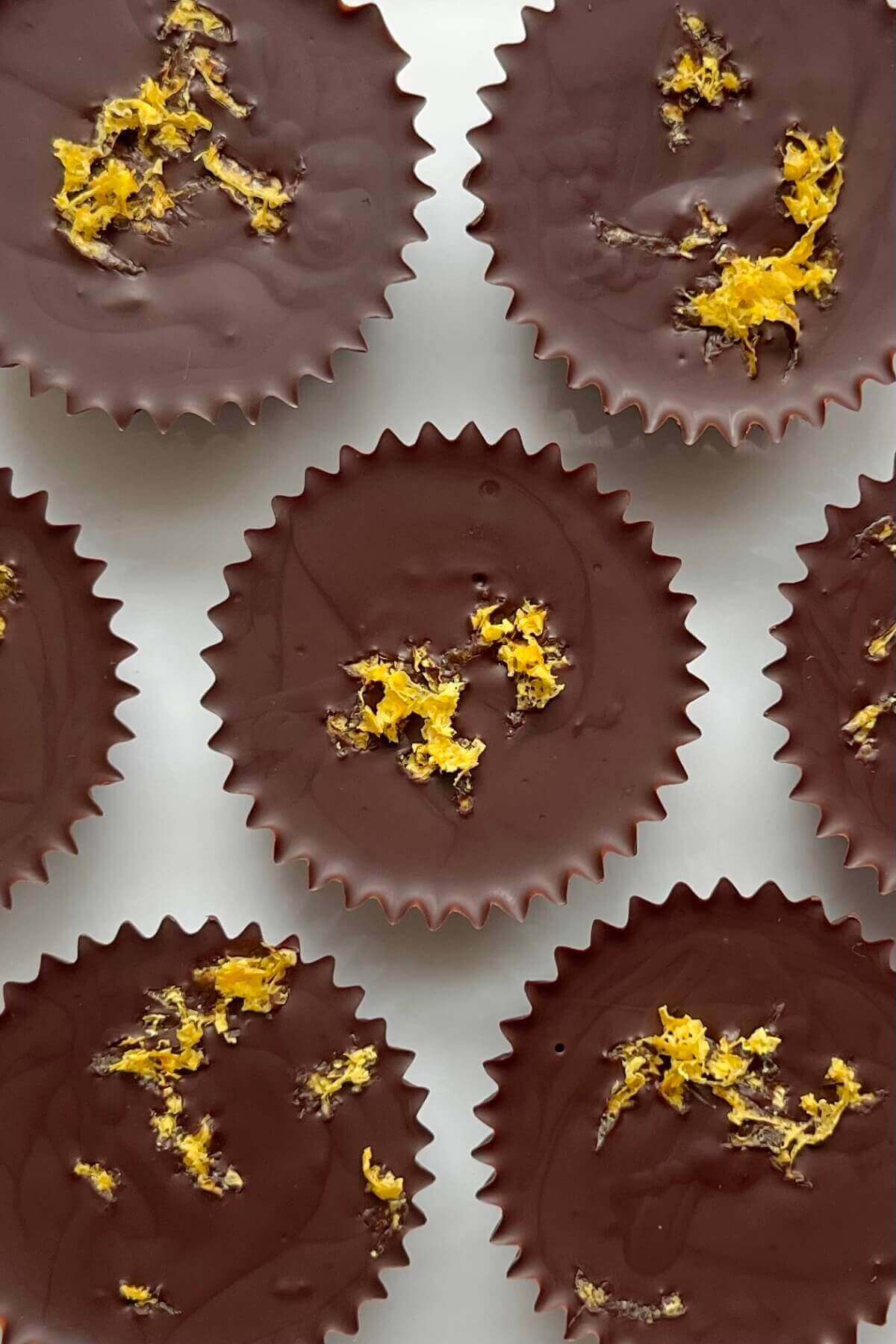 Chocolates sprinkled with lemon zest on a white plate.