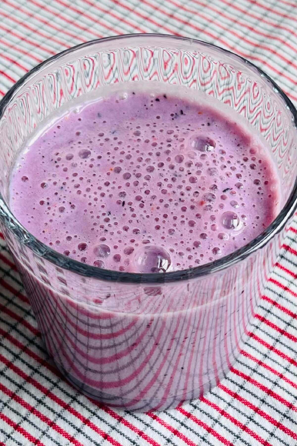 A creamy purple smoothie without bananas in a glass.