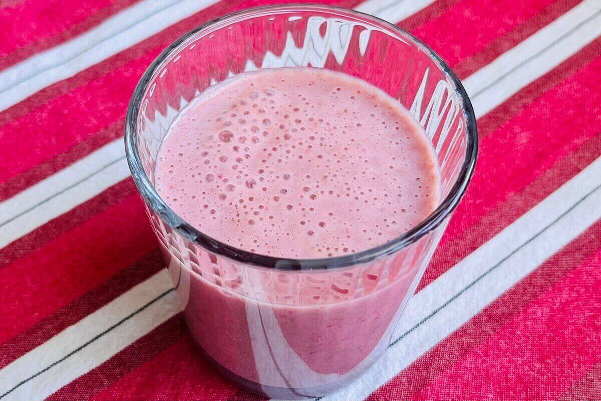 A pink creamy smoothie in a glass.