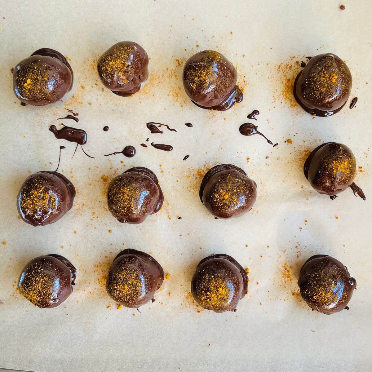 Sweet potato chocolate treats sprinkled with turmeric on parchment paper.