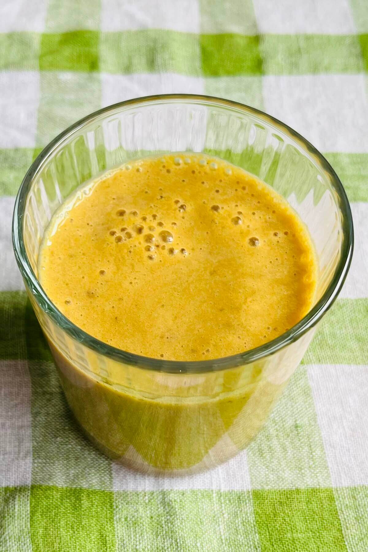 A turmeric and banana smoothie in a glass.