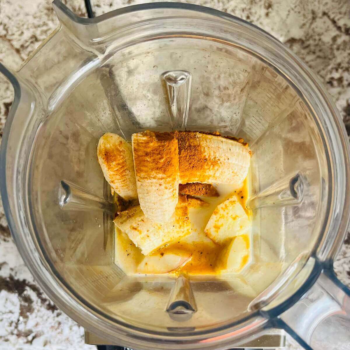 Bananas, chopped apples, soy milk, turmeric, and black pepper in a blender.