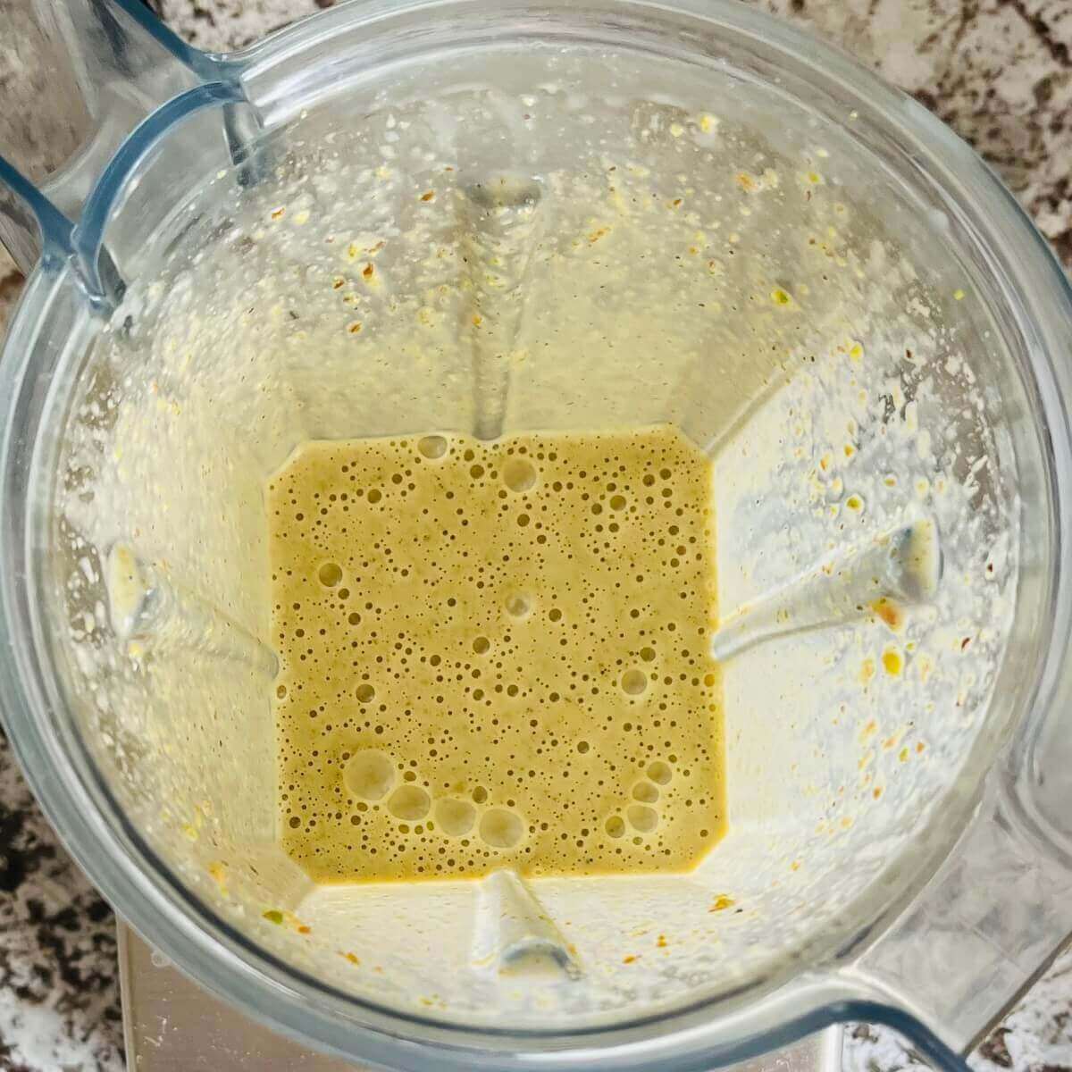 A creamy pale green smoothie in a blender.