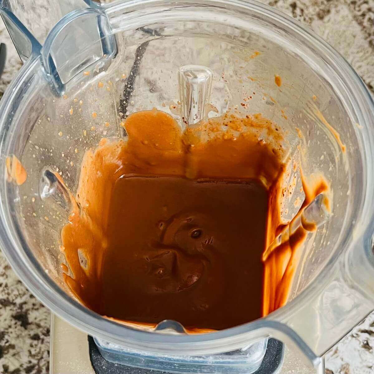 A creamy brown smoothie in a blender.