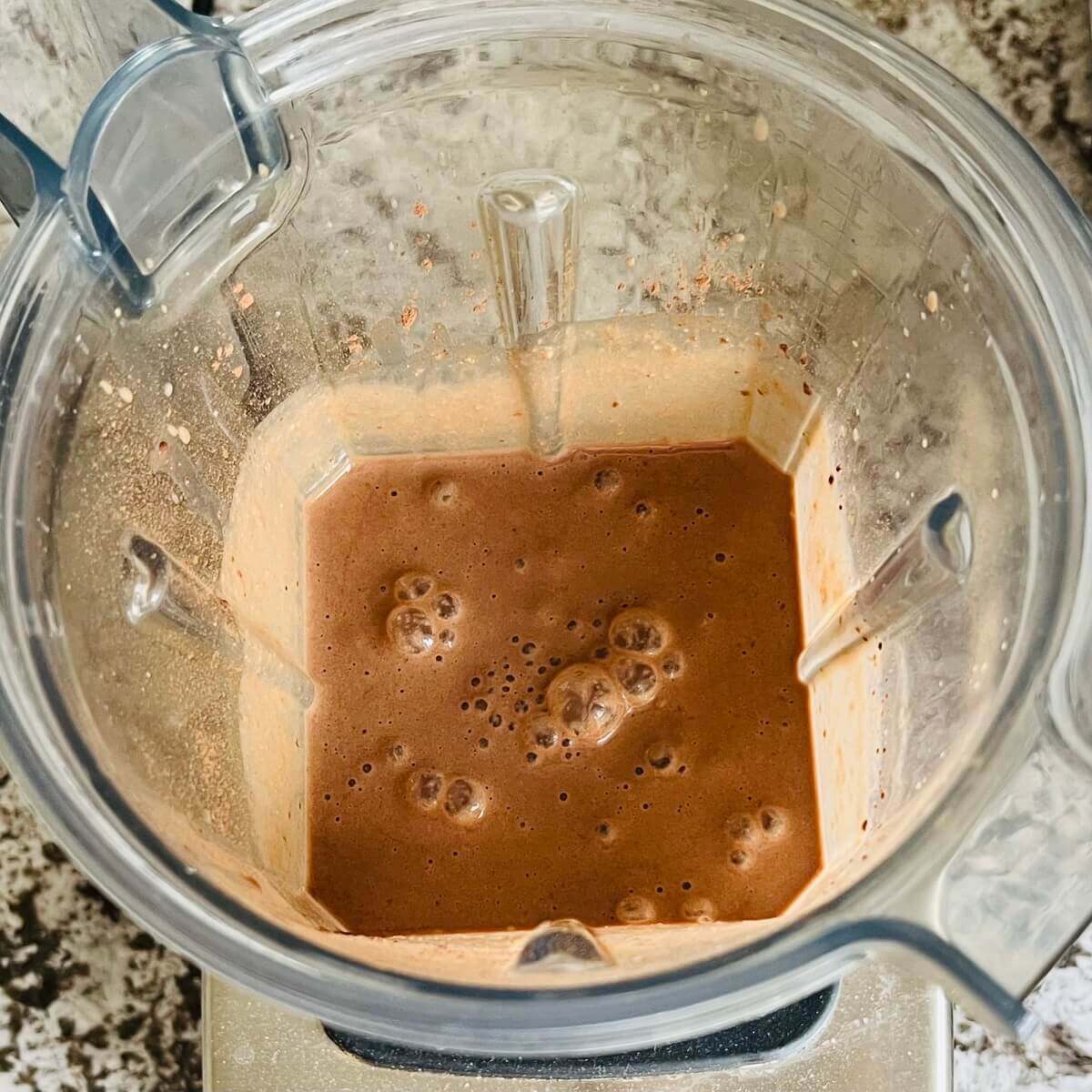 A blended smoothie made with walnuts in a blender.