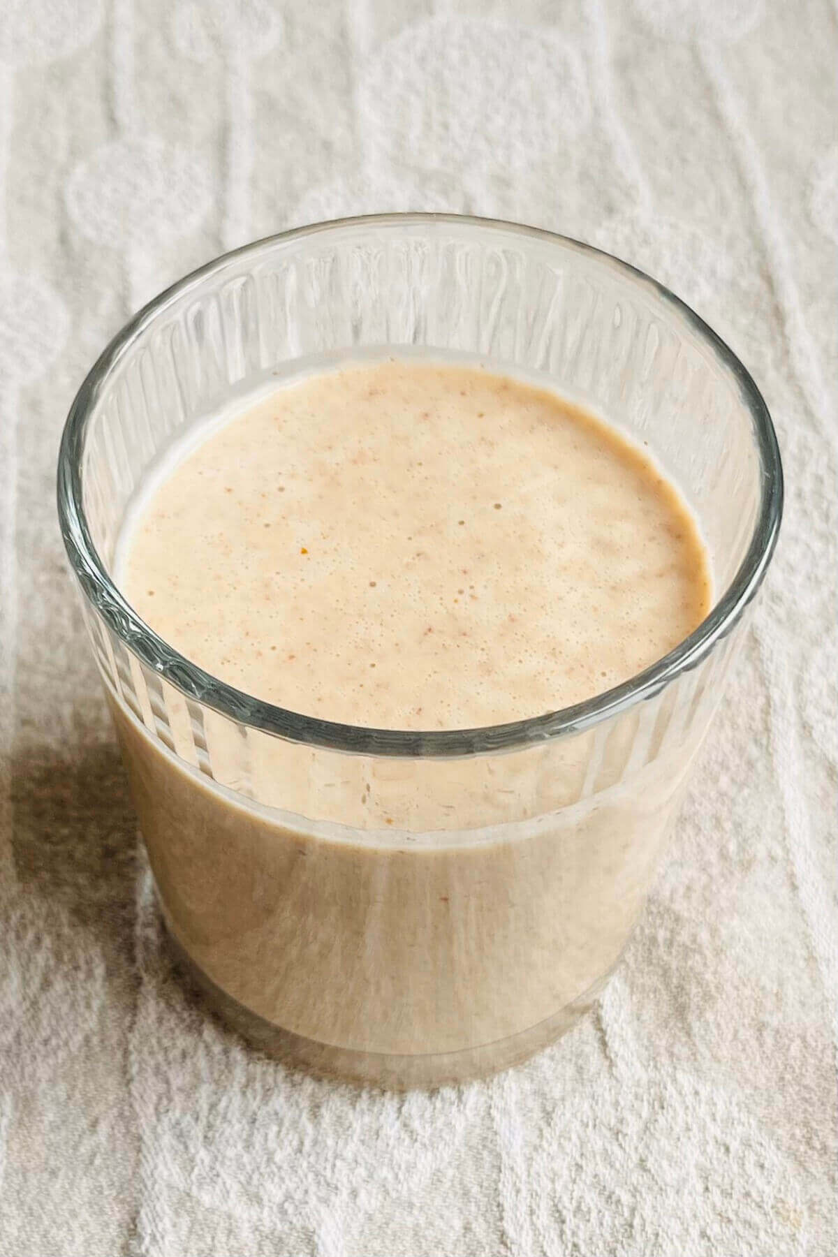 A smoothie made with pecans in a glass.