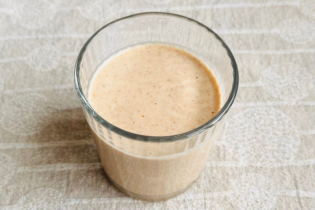 A creamy beige smoothie in a glass.