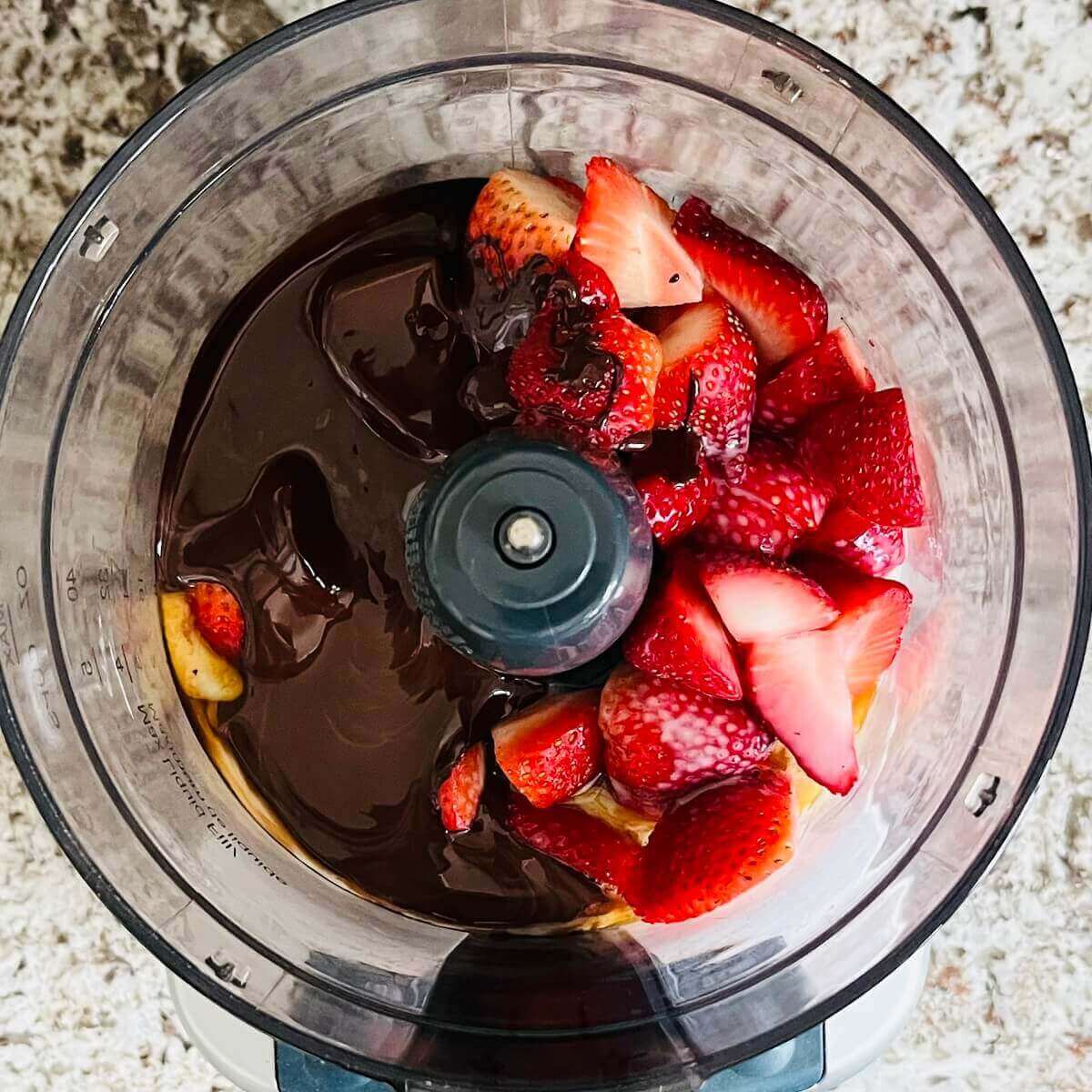 Strawberries, melted chocolate, vanilla, and almond milk in a food processor.