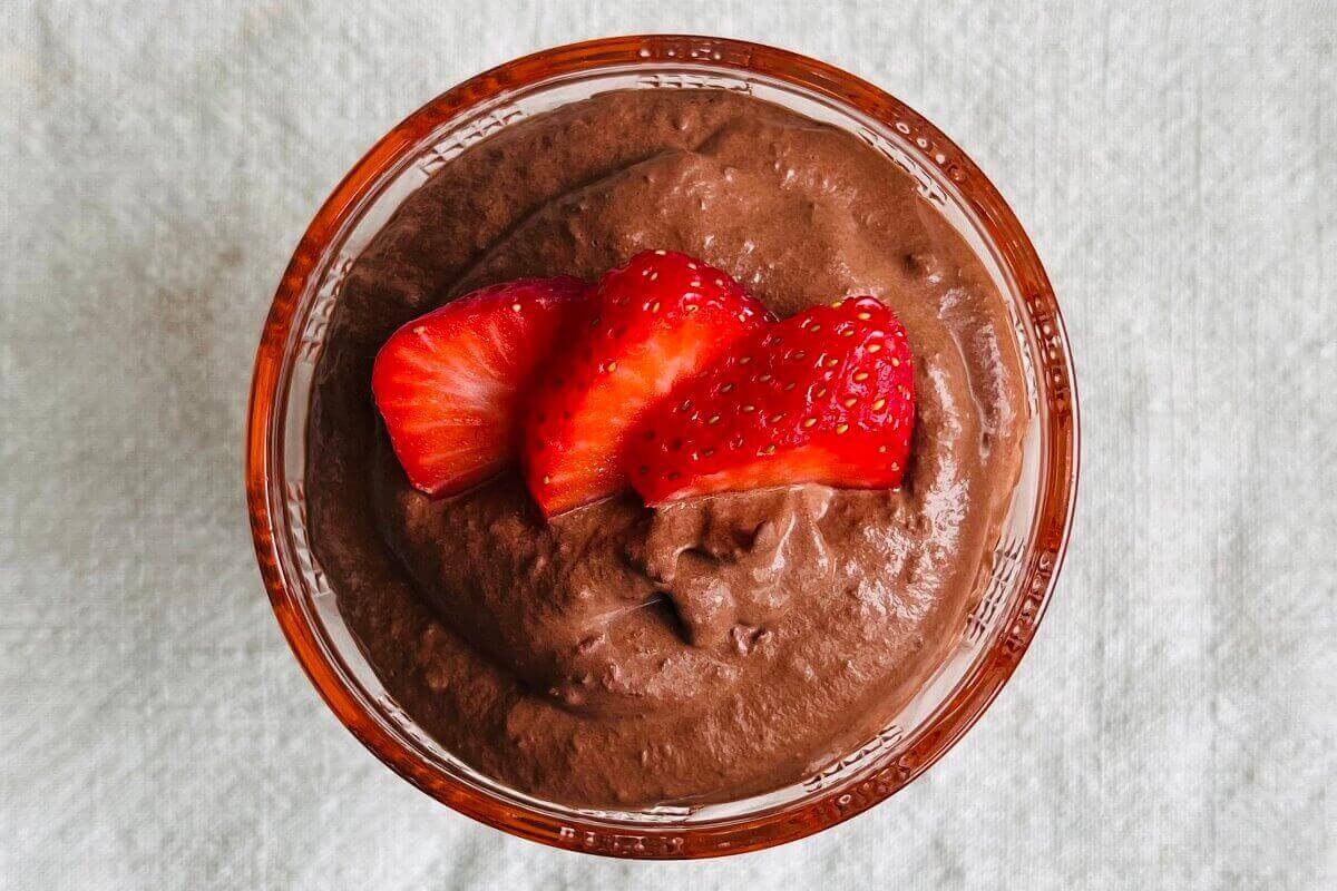 Strawberry chocolate pudding topped with strawberry slices in a glass dish.