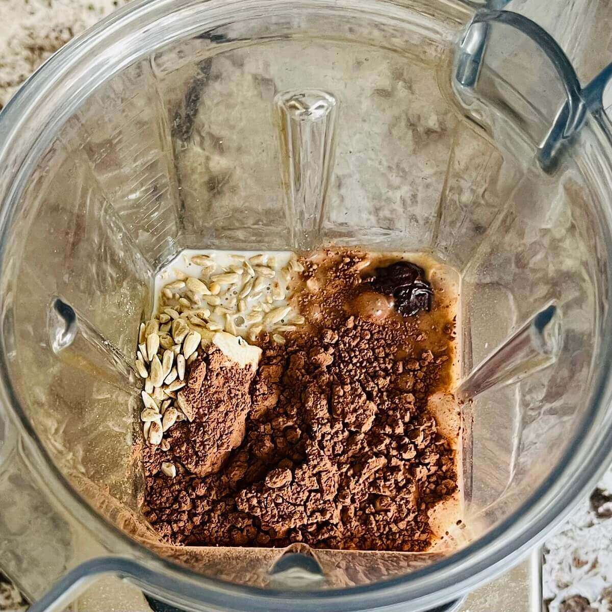 Sunflower seeds and other ingredients for a smoothie in a blender.