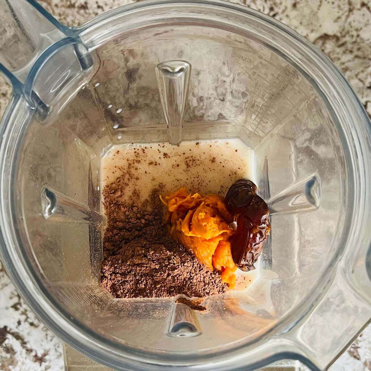 Sweet potato, dates, almond milk, and cocoa powder in a blender.