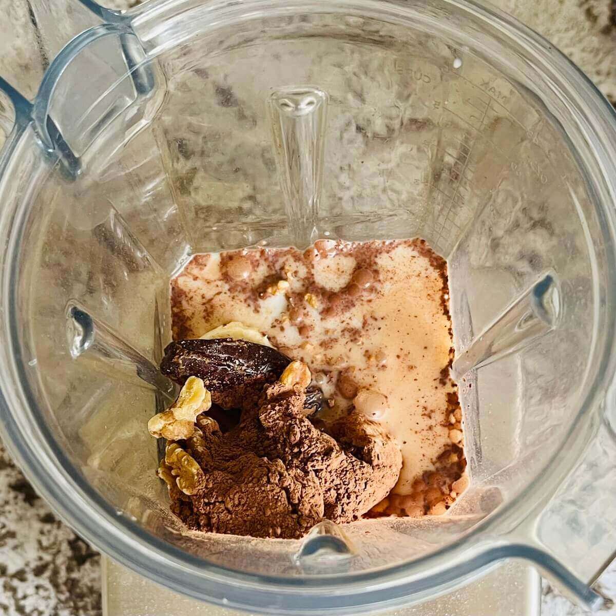 Walnuts and other ingredients in a blender.