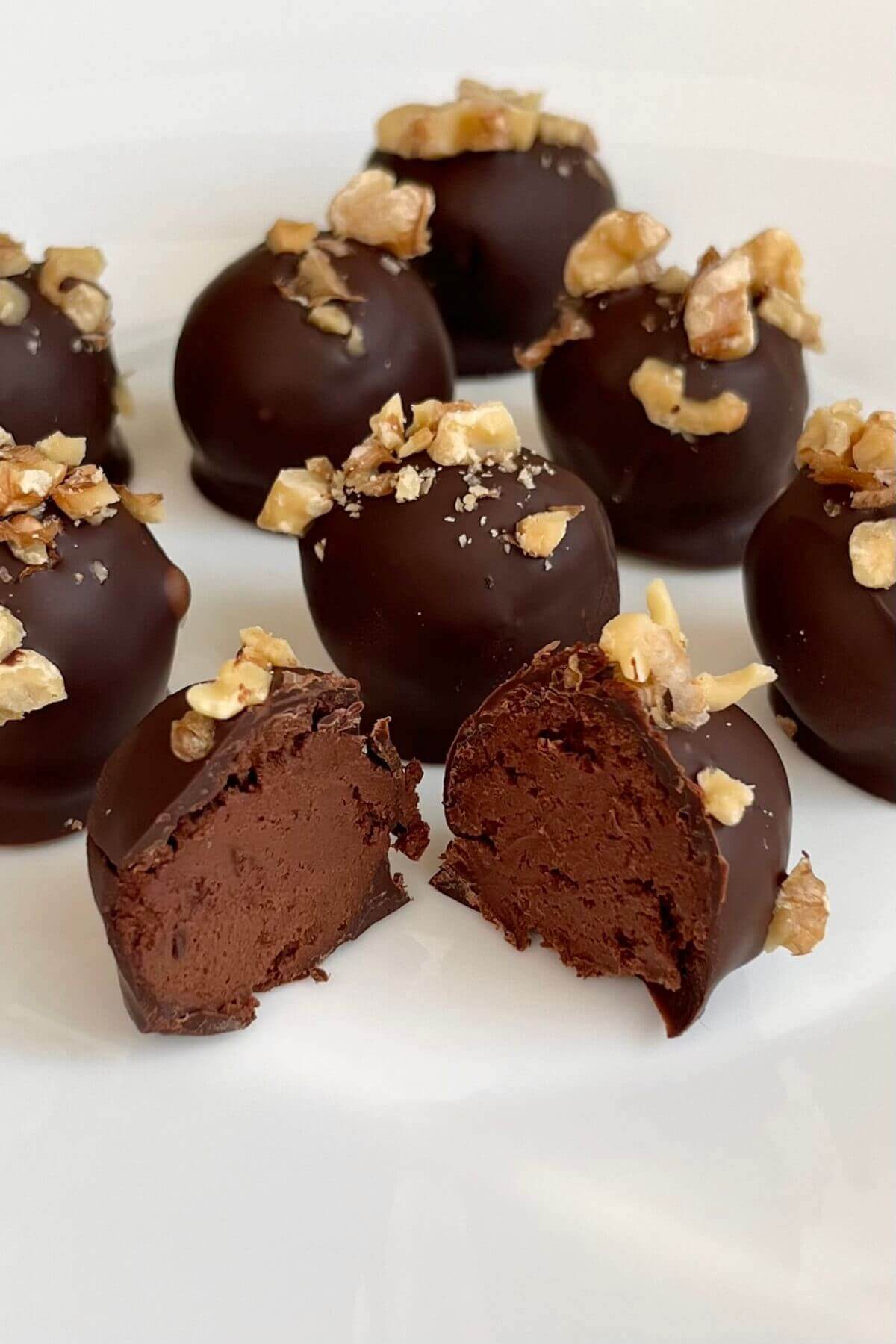 Banana chocolate truffles sprinkled with walnuts on a plate.