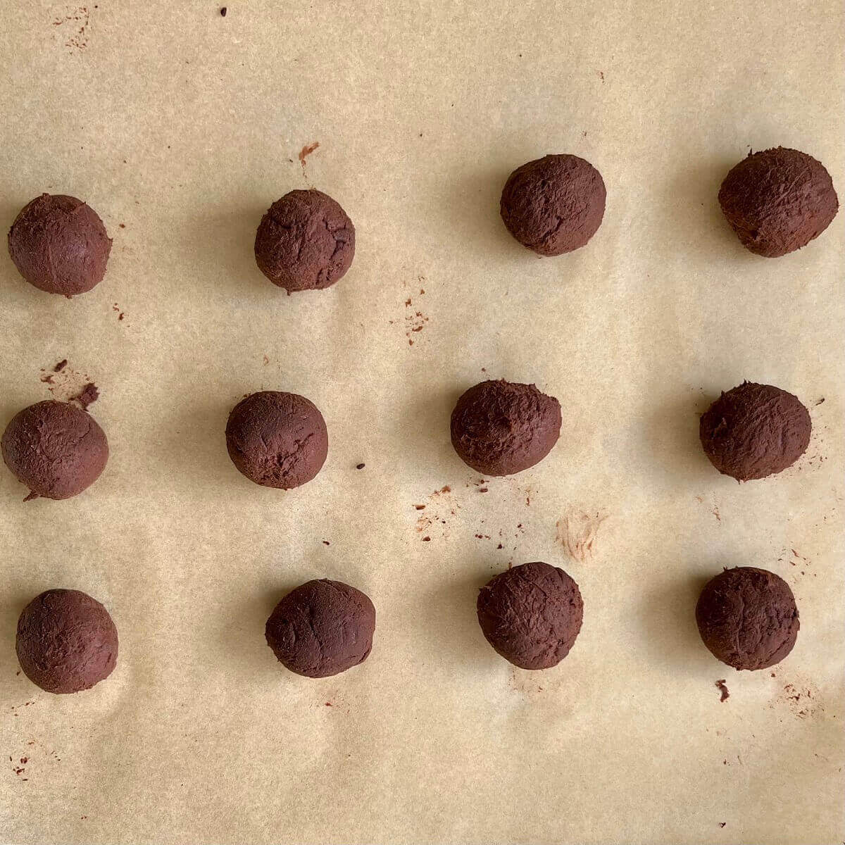 Banana truffle filling formed into balls on a piece of parchment paper.