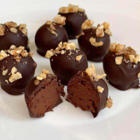 Eight banana truffles on a white plate.