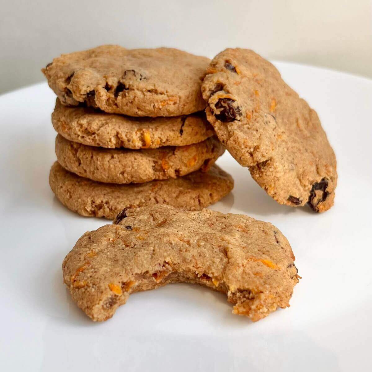 Six vegan carrot cake cookies on a white plate.