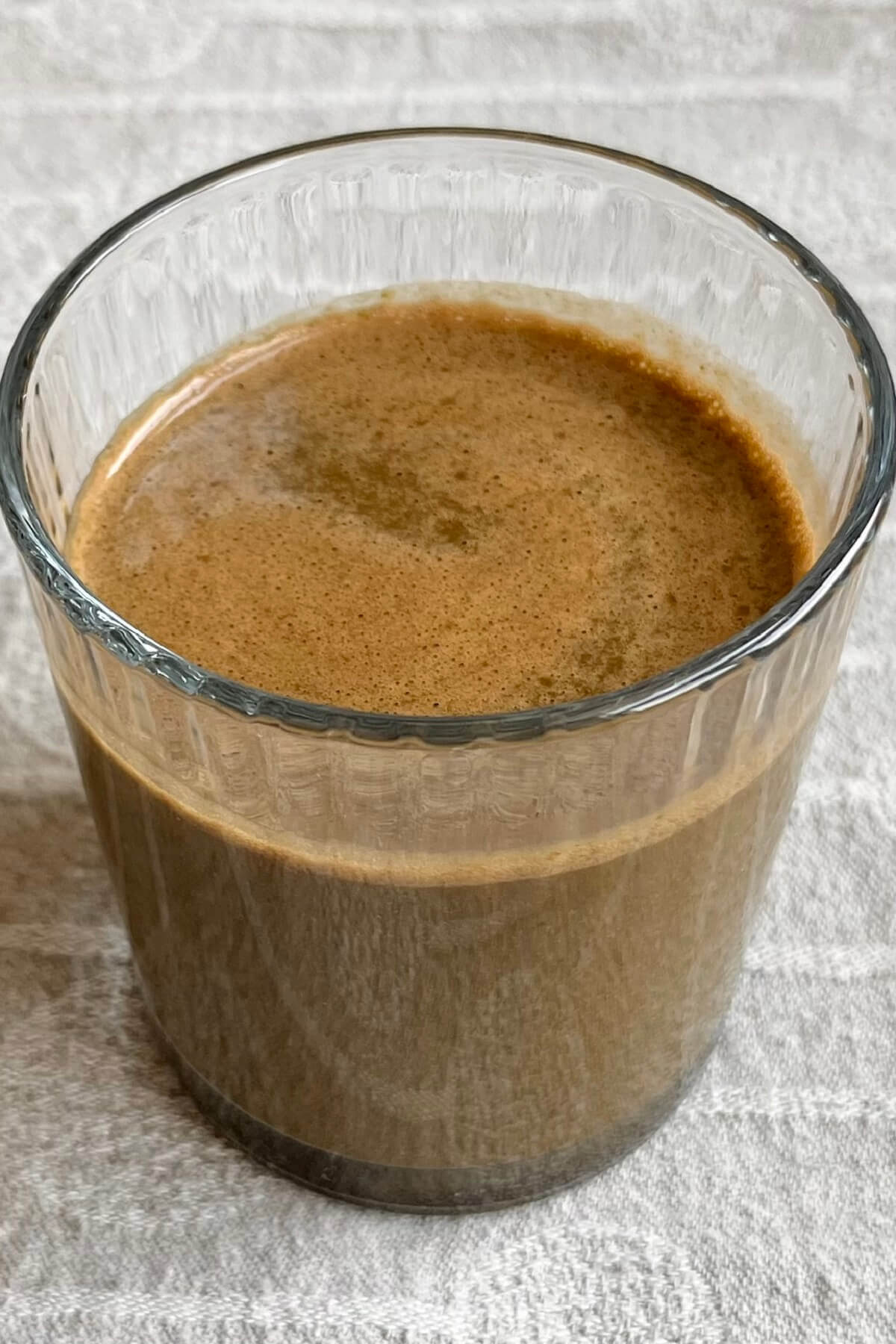A spinach and chocolate smoothie in a glass.