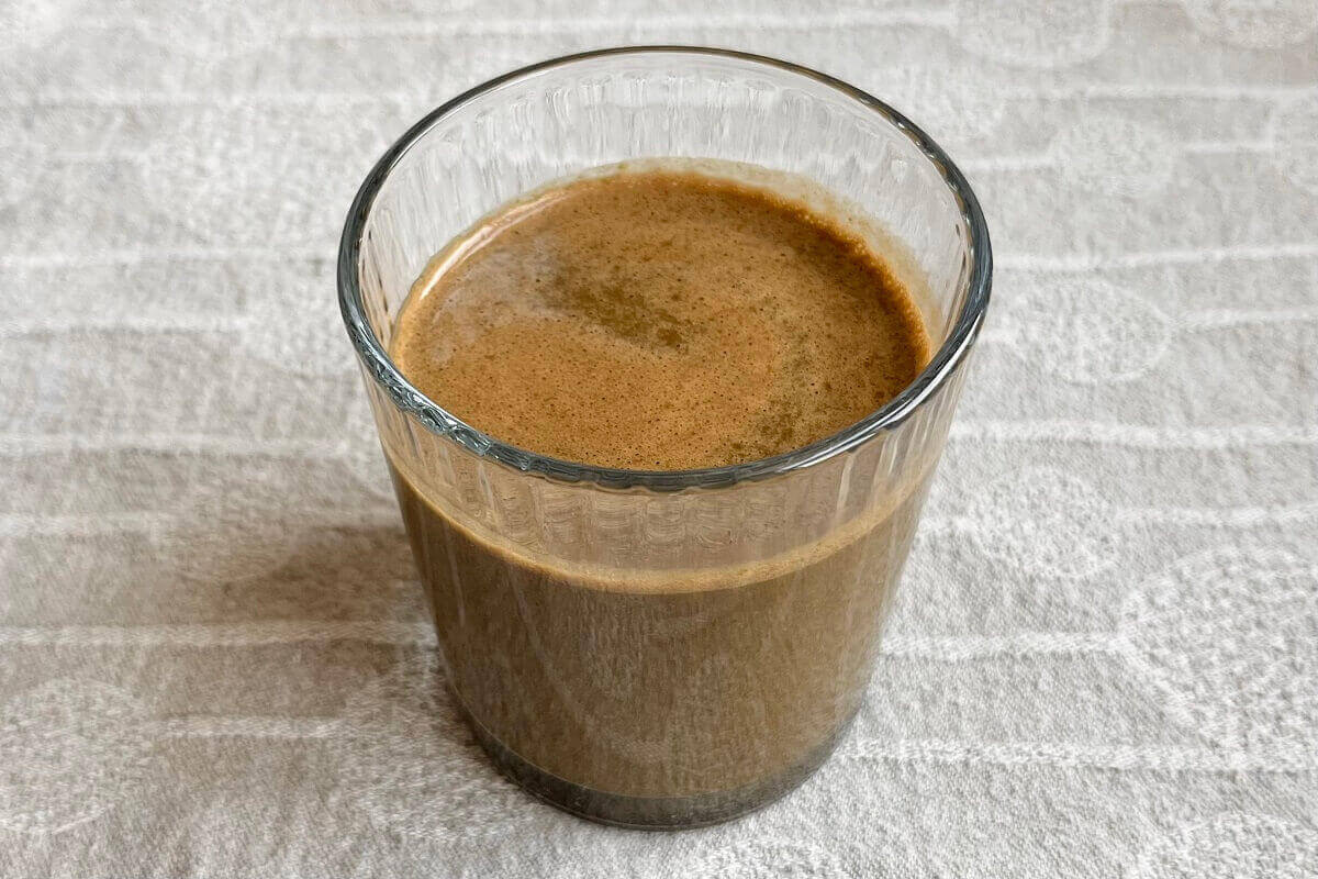 A brown smoothie in a glass.