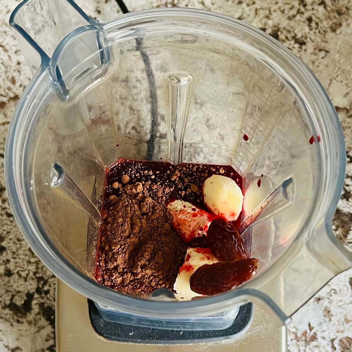 Beet juice and other ingredients for a smoothie in a blender.
