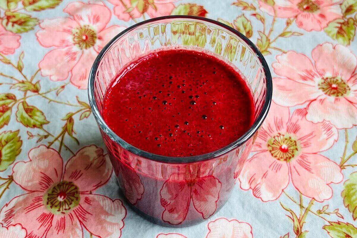 A bright magenta colored smoothie in a glass.
