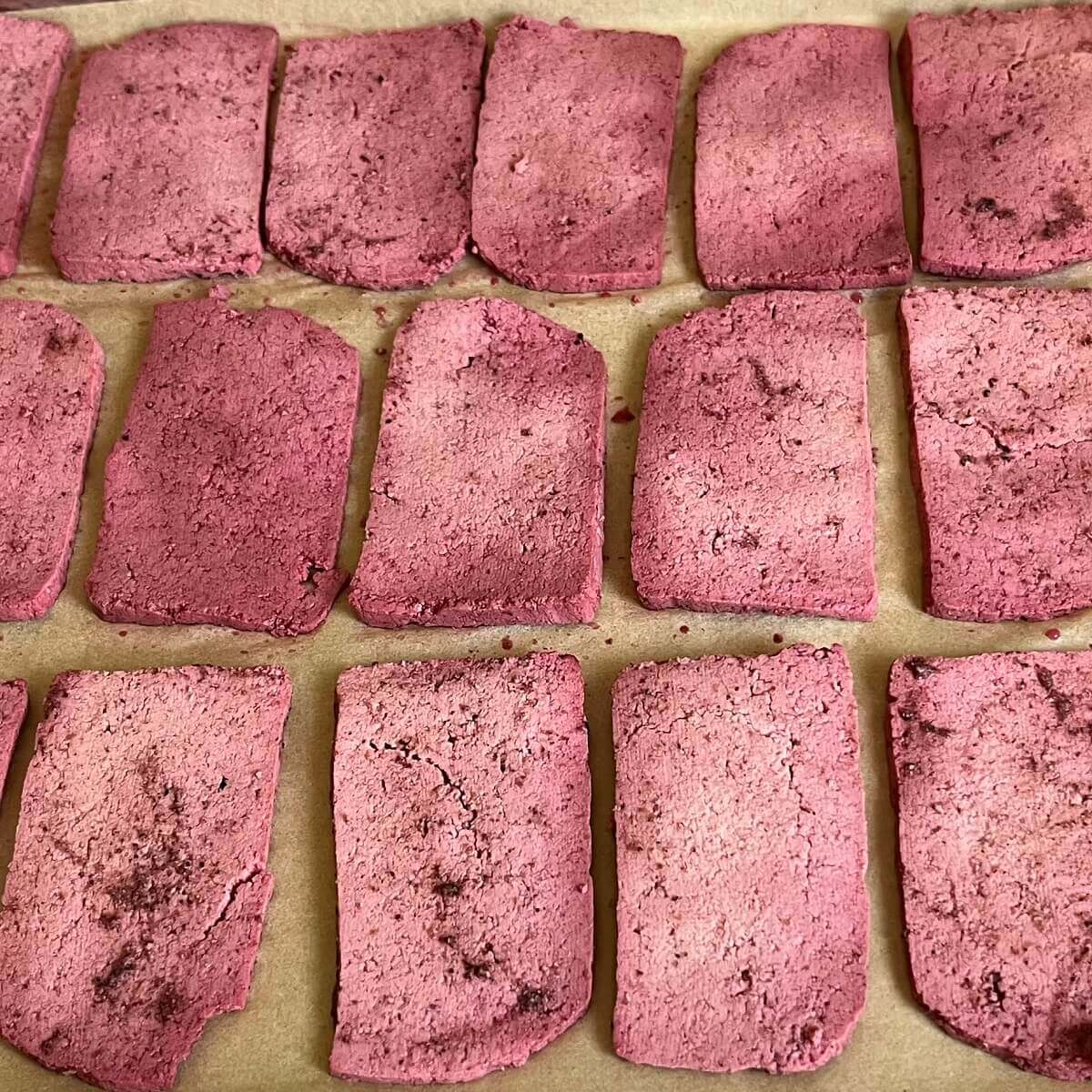 Slices of vegan corned beef on a sheet pan lined with parchment paper.