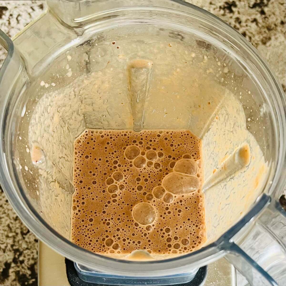 A creamy brown smoothie in a blender.