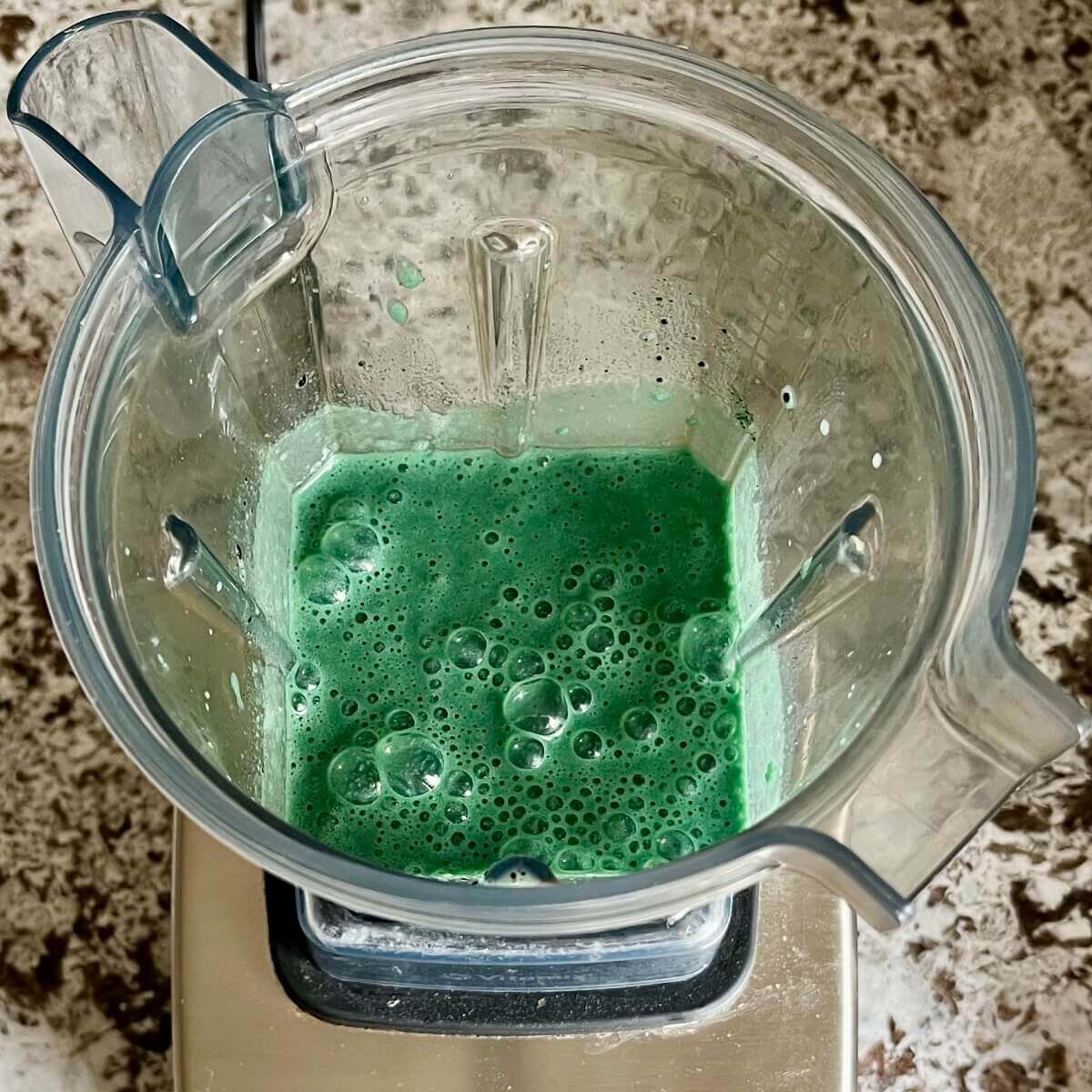 Spirulina and other smoothie ingredients blended in a blender.