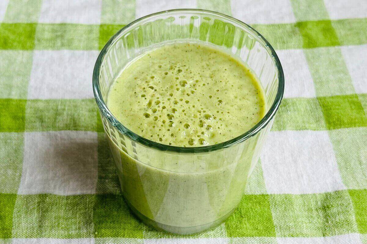 A kiwi and cucumber shake in a glass.