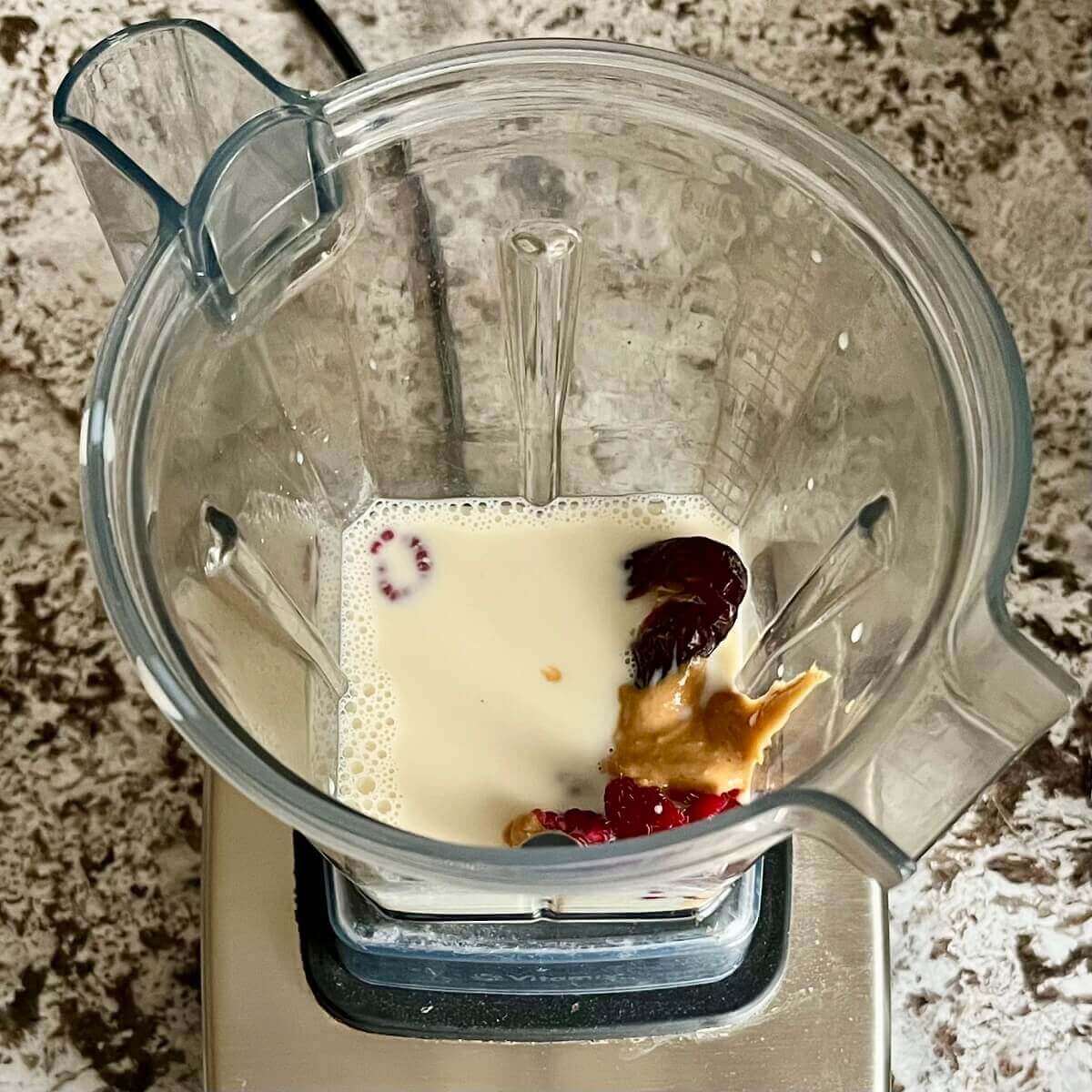 Raspberries, peanut butter, a date, sea salt, and soy milk in a blender.