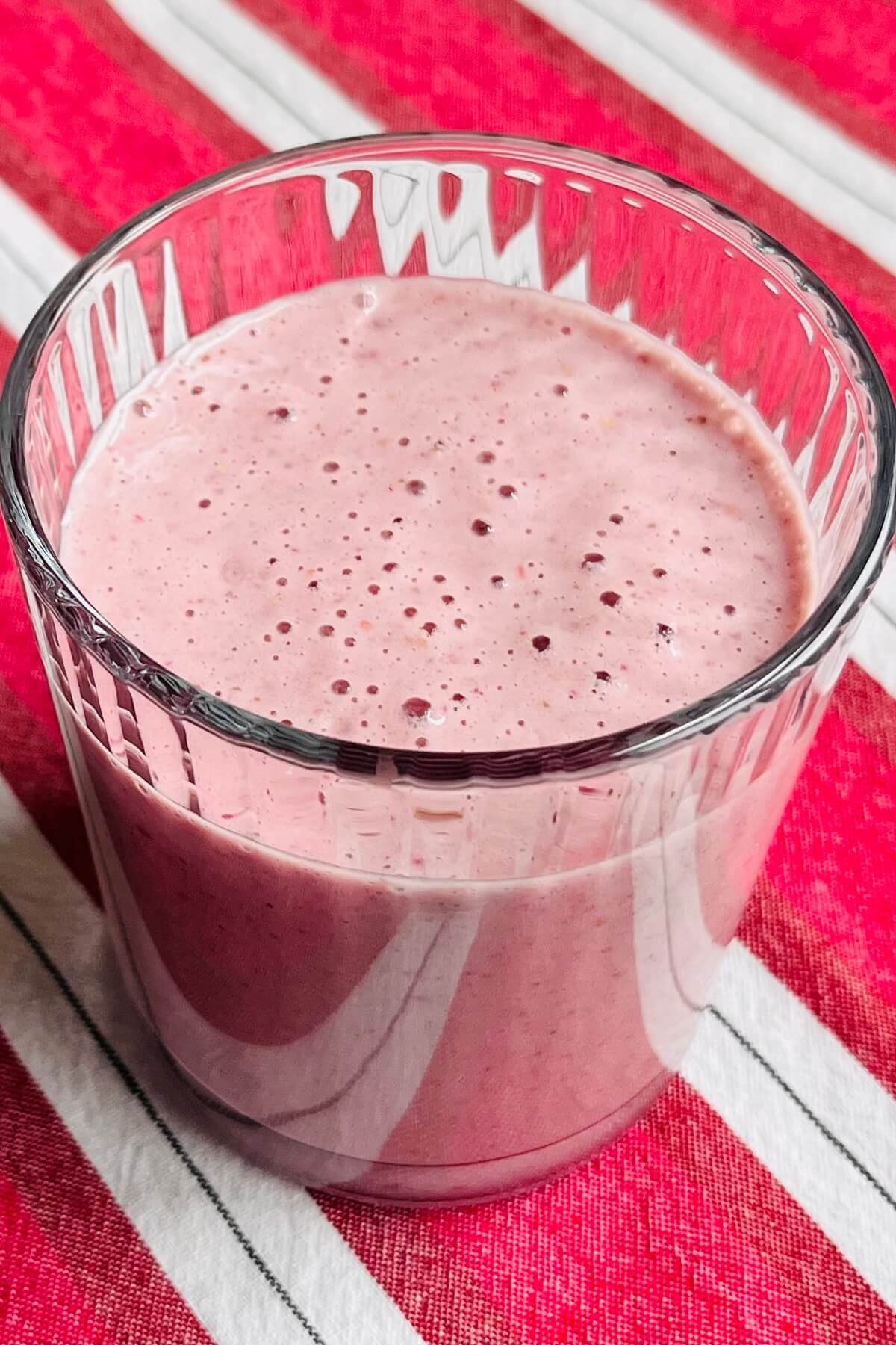 A raspberry peanut butter shake in a glass.