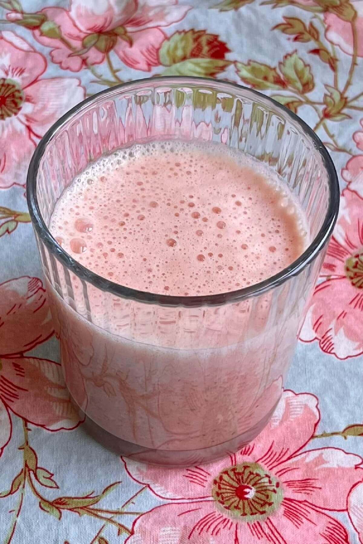 A creamy pink smoothie in a glass.