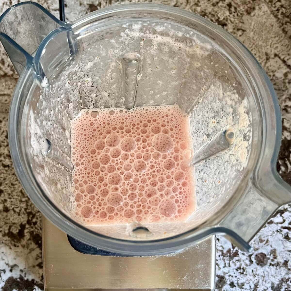 Blended watermelon, lime, soy milk, sea salt, and a date in a blender.