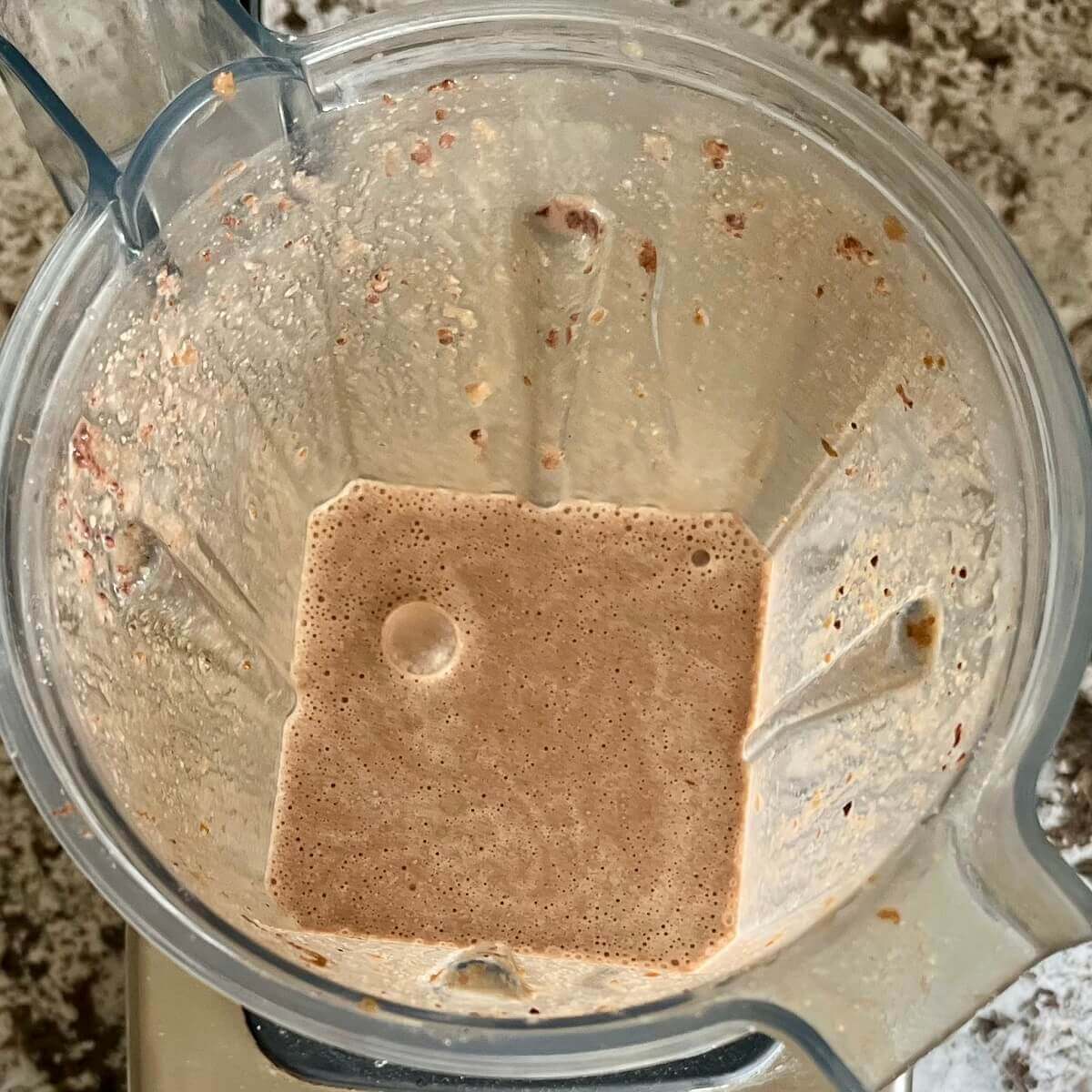Tahini and other ingredients for a smoothie blended in a blender.