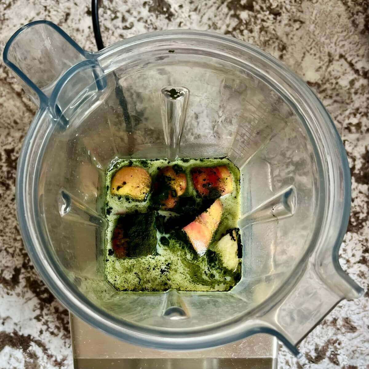 Chlorella powder, banana, apple, vanilla, salt, and soy milk in a blender.