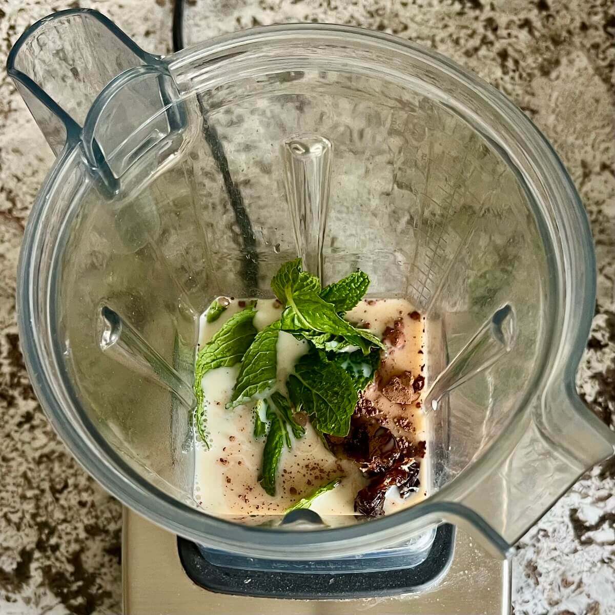 Mint leaves, cocoa powder, dates, soy milk, vanilla, and sea salt in a blender.