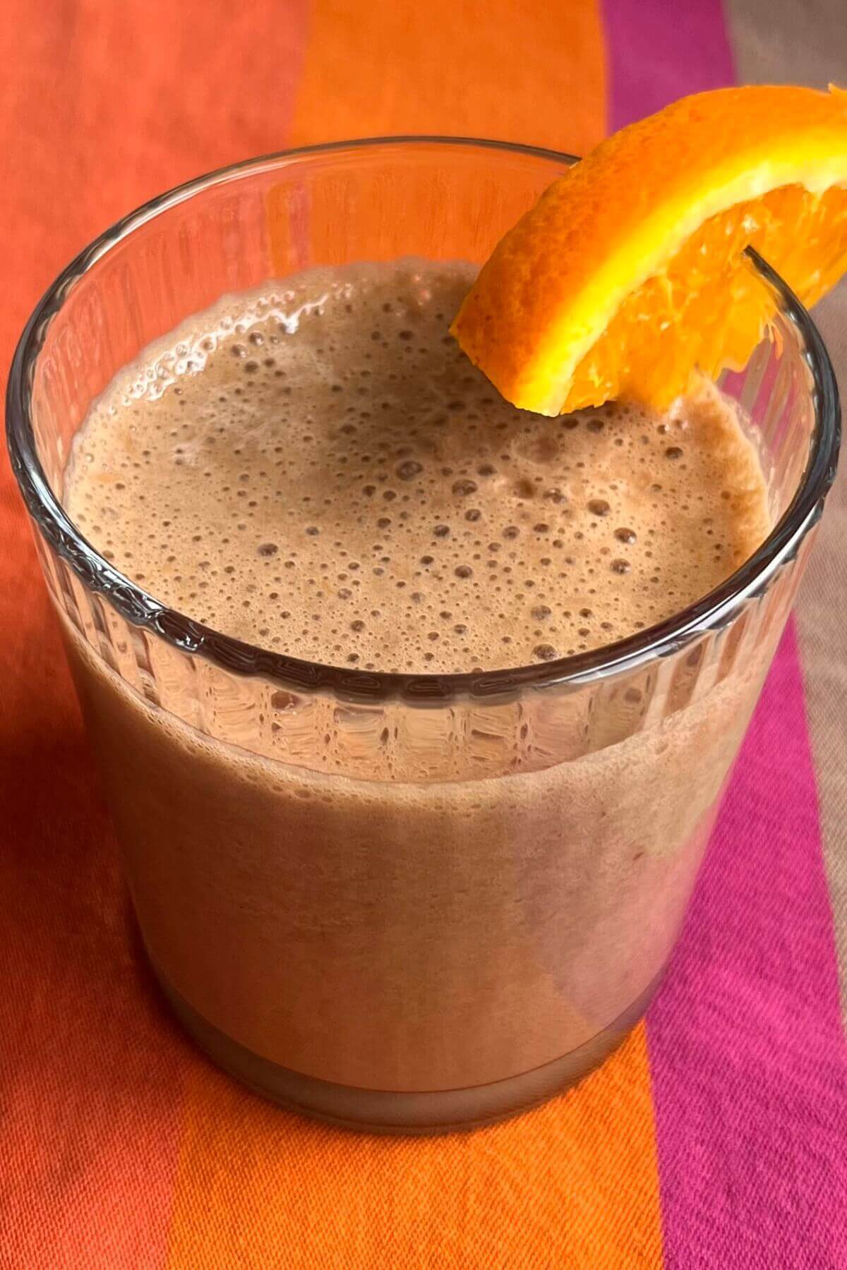An orange chocolate shake in a glass.